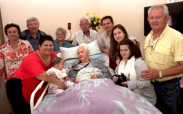 Kinders, kleinkinders, agter-kleinkinders en agter-agter-kleinkind staan bankvas agter Tannie Rens Fourie tydens haar 96ste verjaardag op 25 April vanjaar